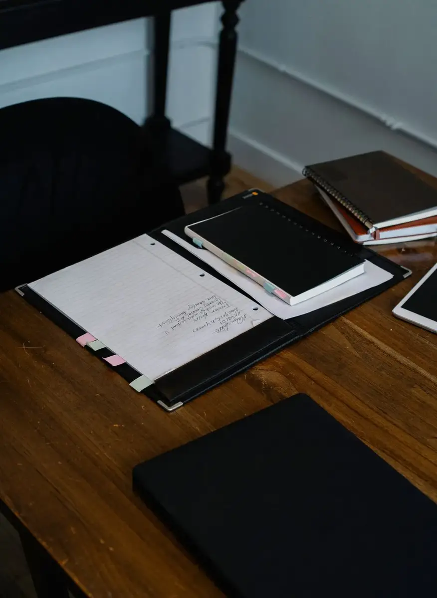 Notebooks and a tablet on a desk